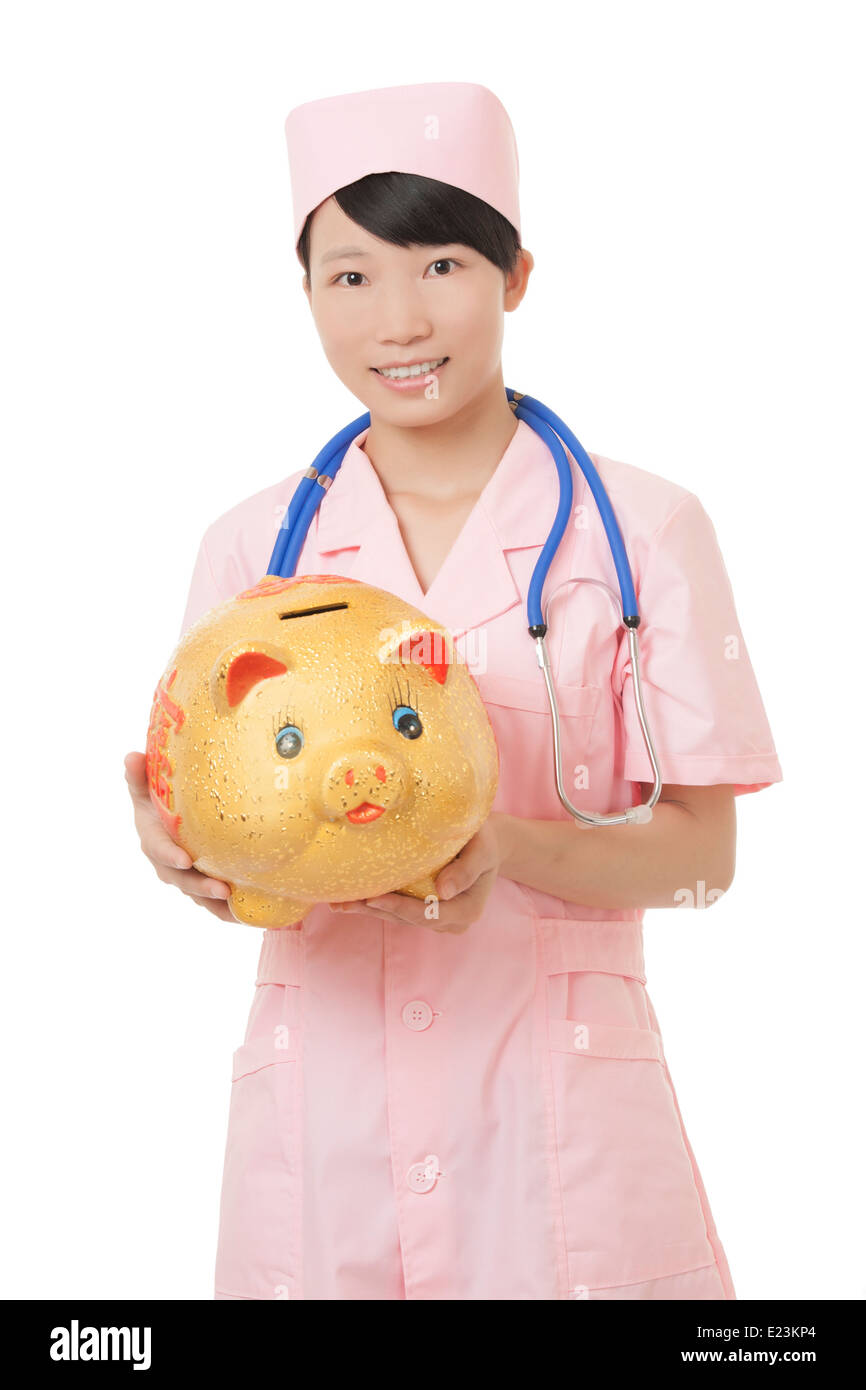 Belle infermiere cinese fingendo di ascoltare il battito cardiaco di un salvadanaio isolato su uno sfondo bianco Foto Stock