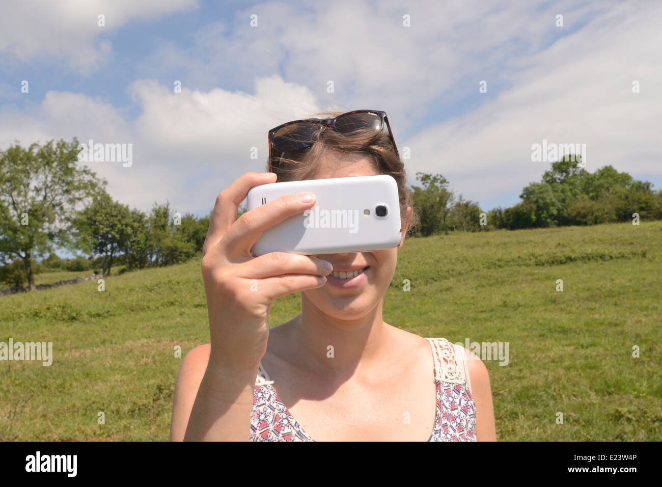 Giovane donna prendendo una foto sul telefono Samsung fotocamera Foto Stock