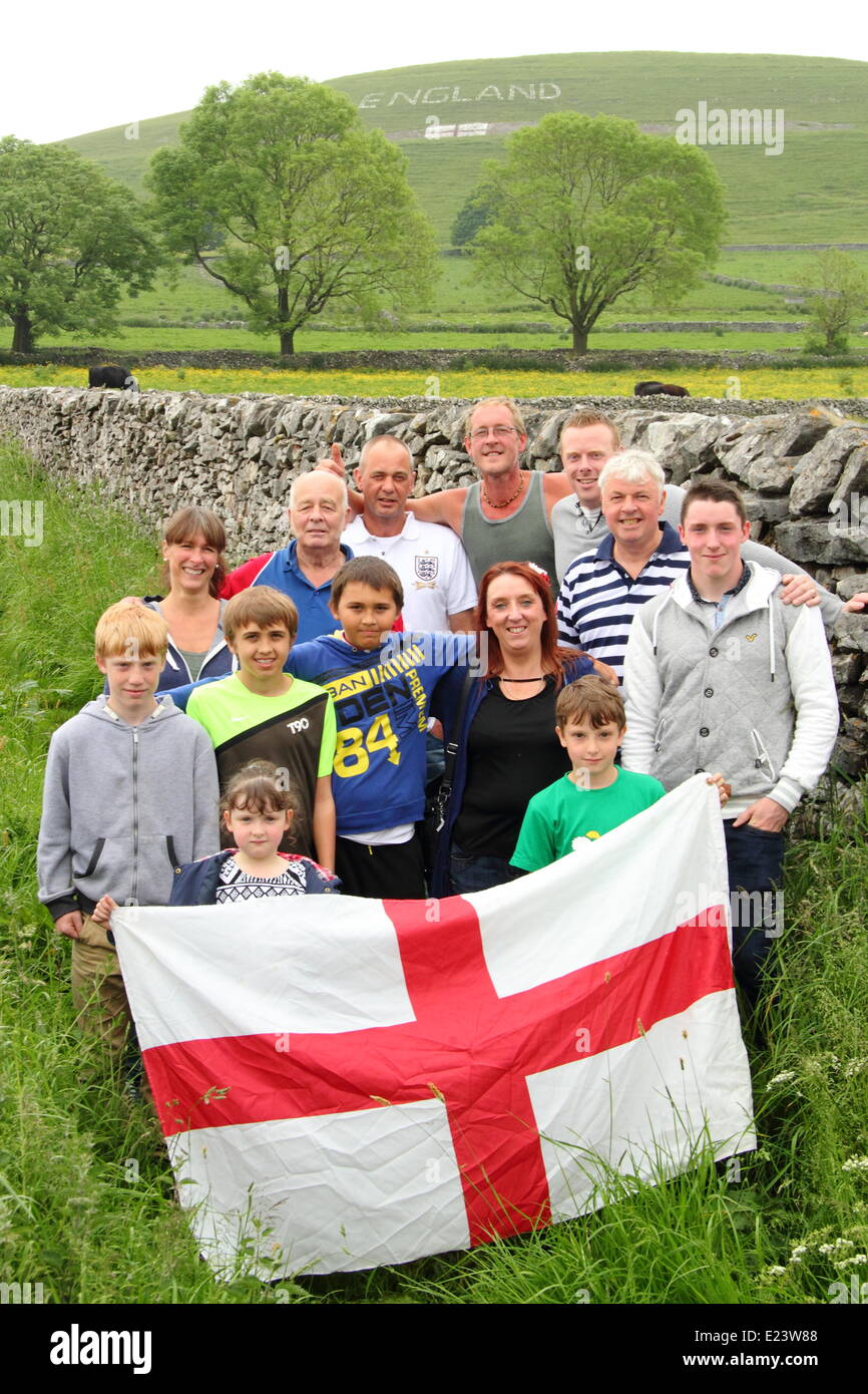 Il Peak District, Derbyshire, Regno Unito. Il 15 giugno 2014. I membri di un gruppo di 15 abitanti di un villaggio che hanno creato un segno in su una collina sopra il villaggio Chelmorton vicino a Buxton. Residente locale Phil Swindell, 44, rimane ottimista circa l'Inghilterra del probabilità nonostante la loro sconfitta contro l'Italia. Il costruttore ha detto: "Penso che abbiamo fatto bene ma lo rende molto difficile. Ci andrà tutto bene. Gli ottimisti non siamo." Credito: Matthew Taylor/Alamy Live News Foto Stock