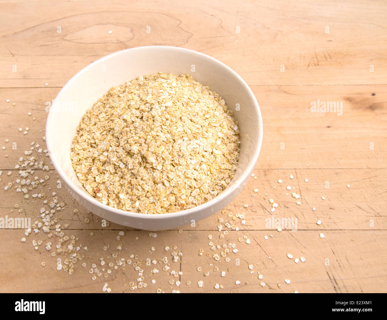 La quinoa fiocchi in un bianco terrina su una tavola di legno(10 di 18) Foto Stock
