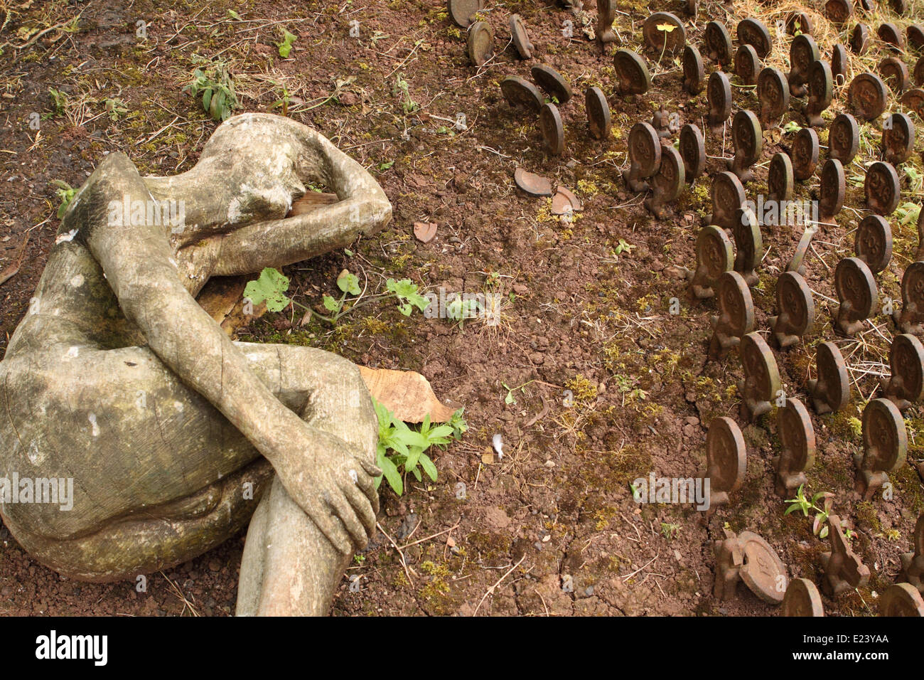 L'ex Somerset e bagno Manicomio cimitero di Wells Somerset. La scultura in legno da artista Peter Bolton mostra l'angoscia di salute mentale di affiancare i dischi di ferro utilizzato per contrassegnare le tombe anonime del detenuto pazienti. Foto Stock