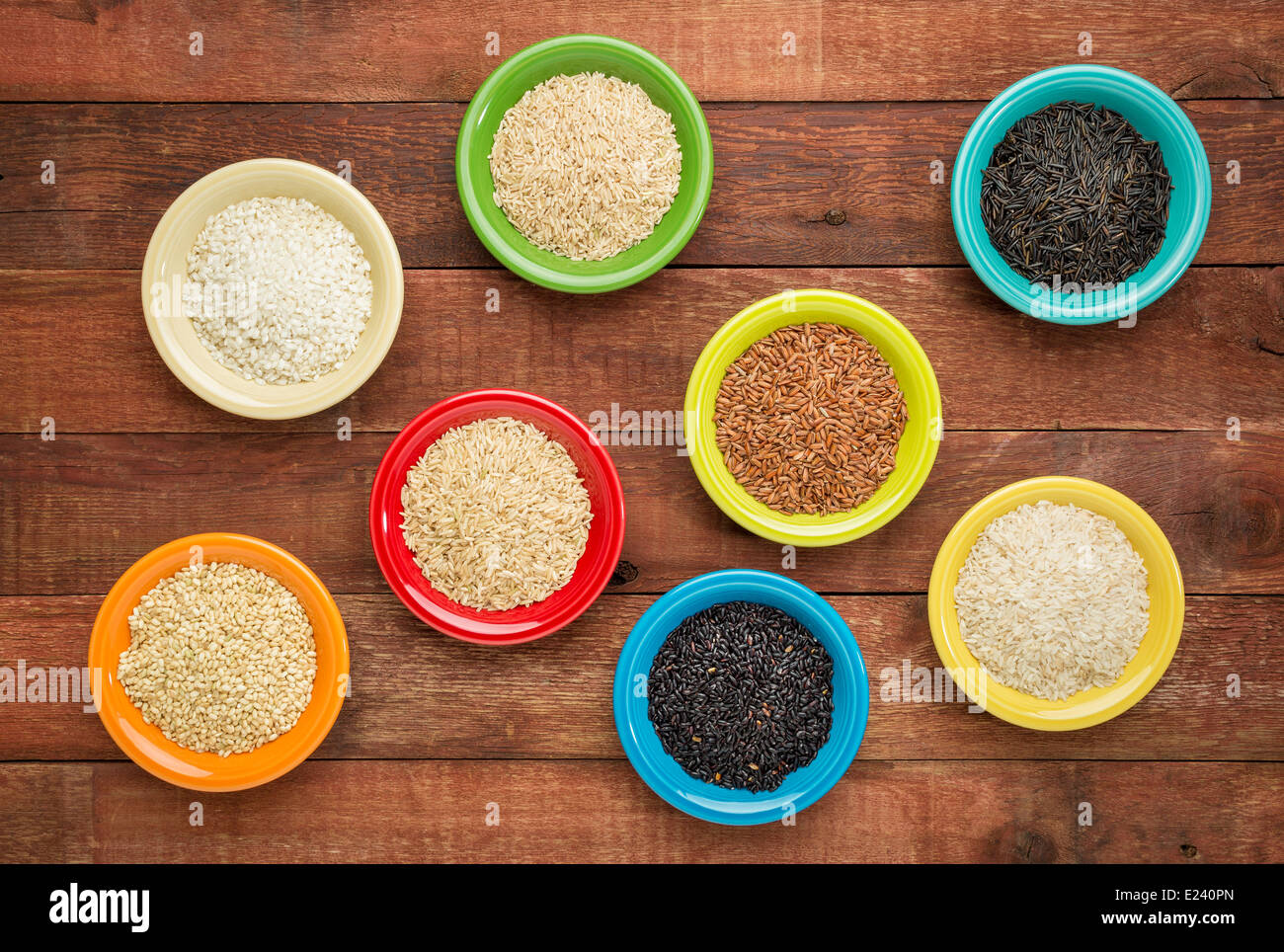 Riso astratto di bocce su un rustico rosso fienile legno - una varietà di cereali Foto Stock