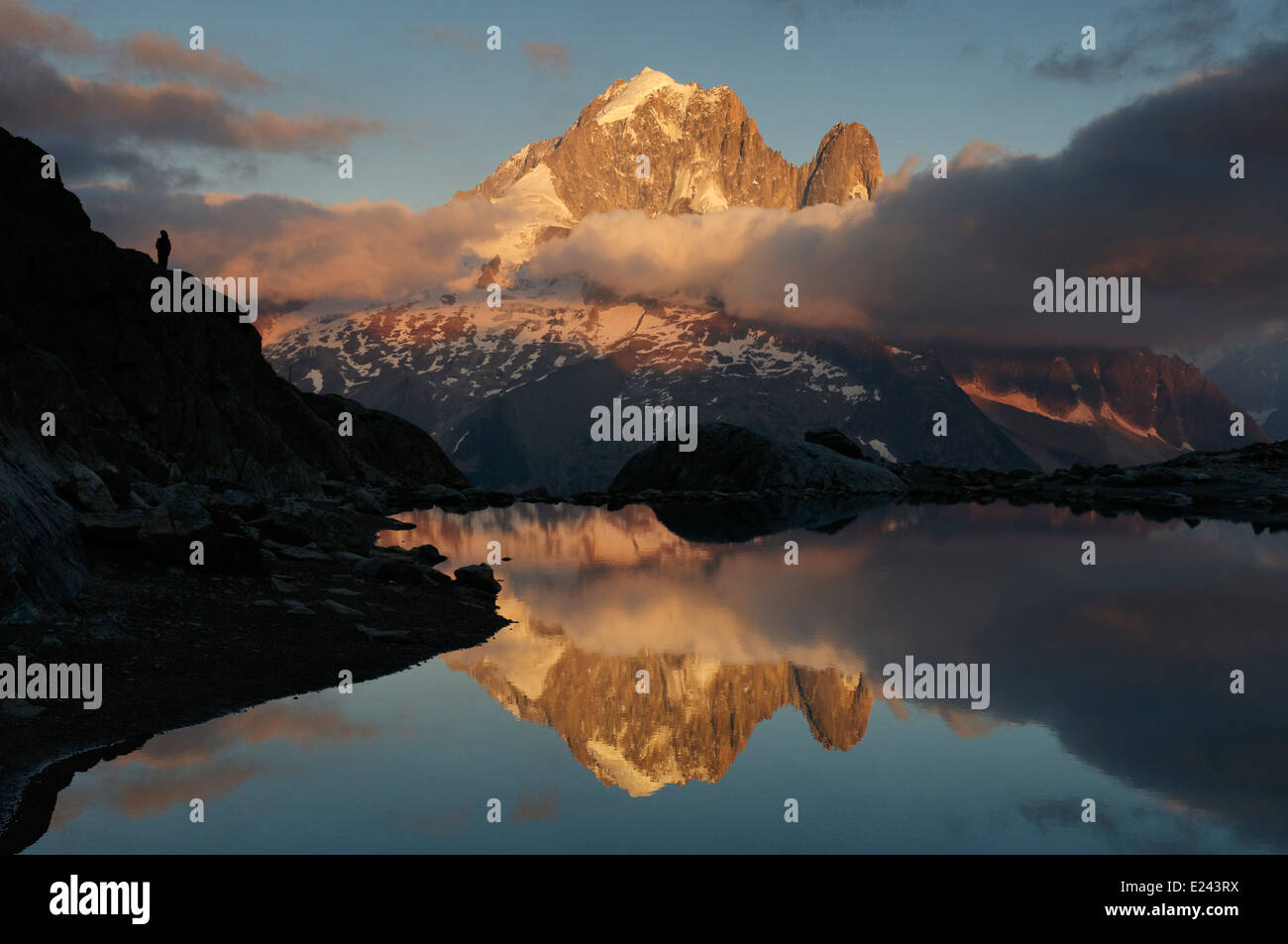 Una persona solitaria watcing tramonto sulla Aiguille Verte riflessa in Lac Blanc, Chamonix, Francia Foto Stock