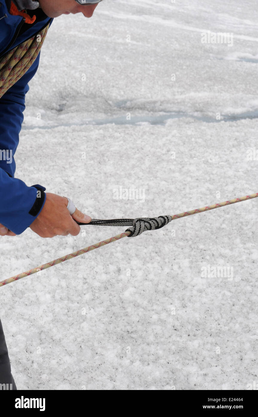 Una guida di montagna dimostra facendo un nodo prusik e come impostare una corda per il crepaccio sul soccorso alpino un corso di arrampicata Foto Stock