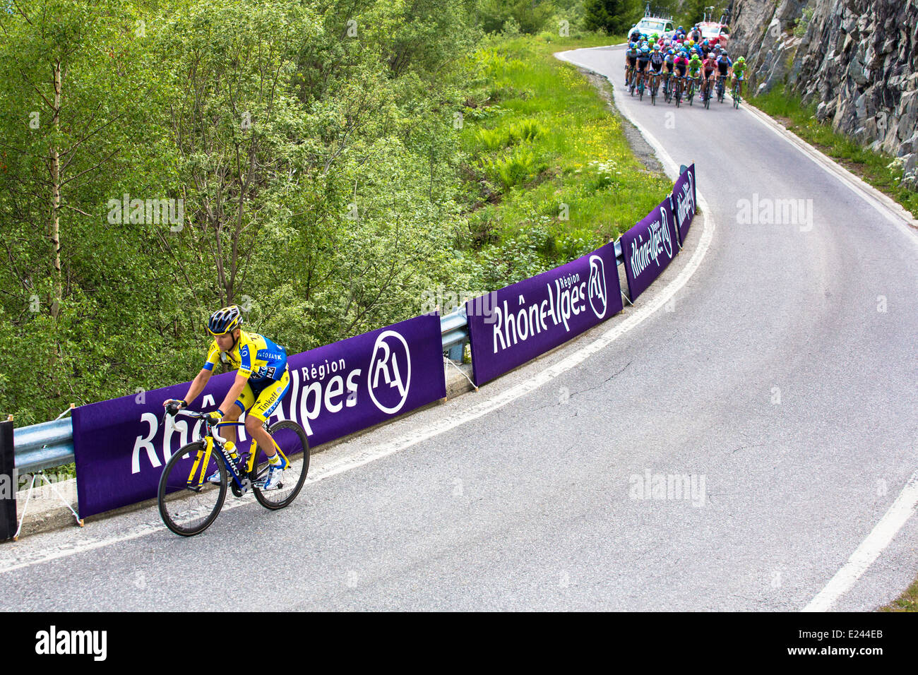 Una bici racer è inseguito da un gruppo di motociclisti nel peloton durante il Criterium du Dauphiné gara stage 7 in Svizzera Foto Stock