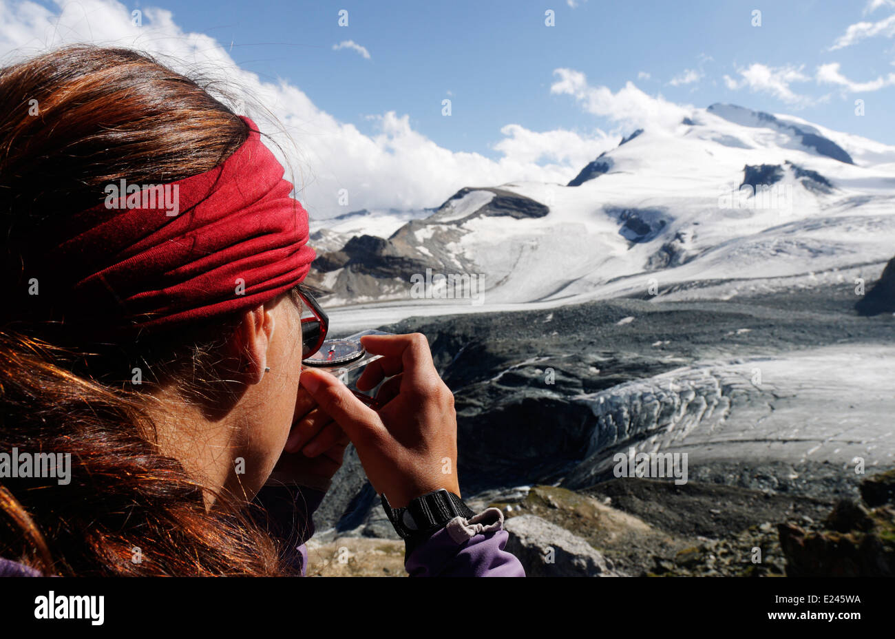 Una signora scalatore prendendo un avvistamento al vertice del Strahlhorn nelle alpi svizzere, preparando la via per i prossimi giorni salita Foto Stock