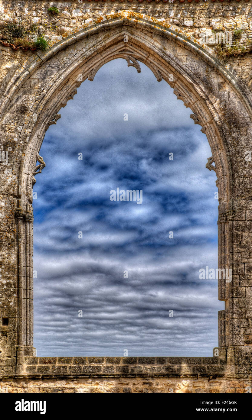 Guardando un cielo nuvoloso attraverso una rovina la finestra della chiesa Foto Stock