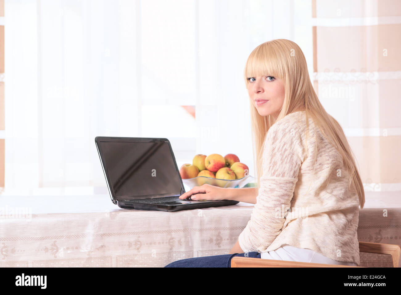 Ritratto di una giovane donna con un computer portatile a casa Foto Stock