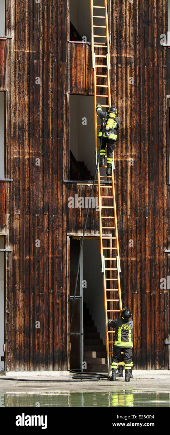 Due vigili del fuoco con grande scala durante una sessione di prove al firehouse Foto Stock