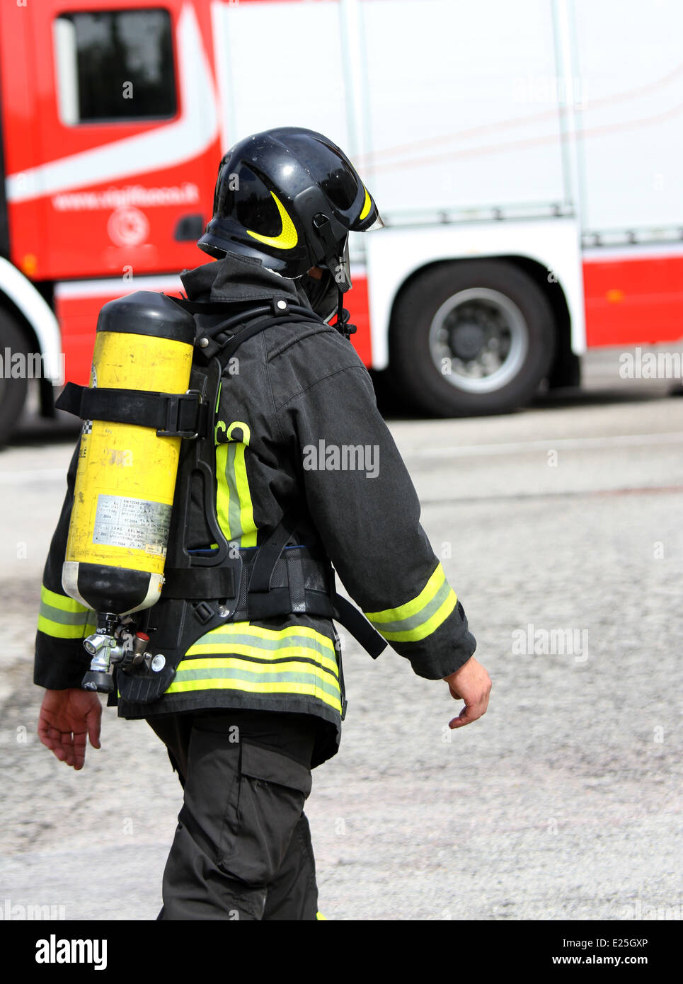 Vigile del fuoco italiano con la bombola di ossigeno e il casco cammina  verso il fuoco Foto stock - Alamy