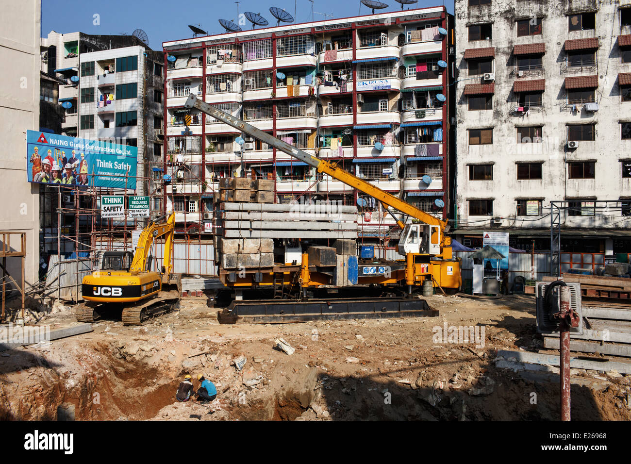 Un edificio di nuova costruzione con macchine moderne in un luogo di un demolito uno nel centro di Yangon, Myanmar (Birmania) Foto Stock