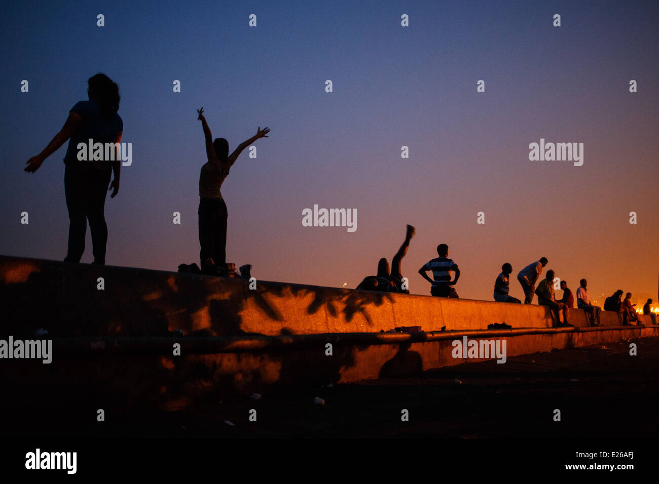 Persone che praticano lo yoga, meditazione e che esercitano sul sentiero lungomare lungo Marine Drive all'alba sunrise in Mumbai, India Foto Stock