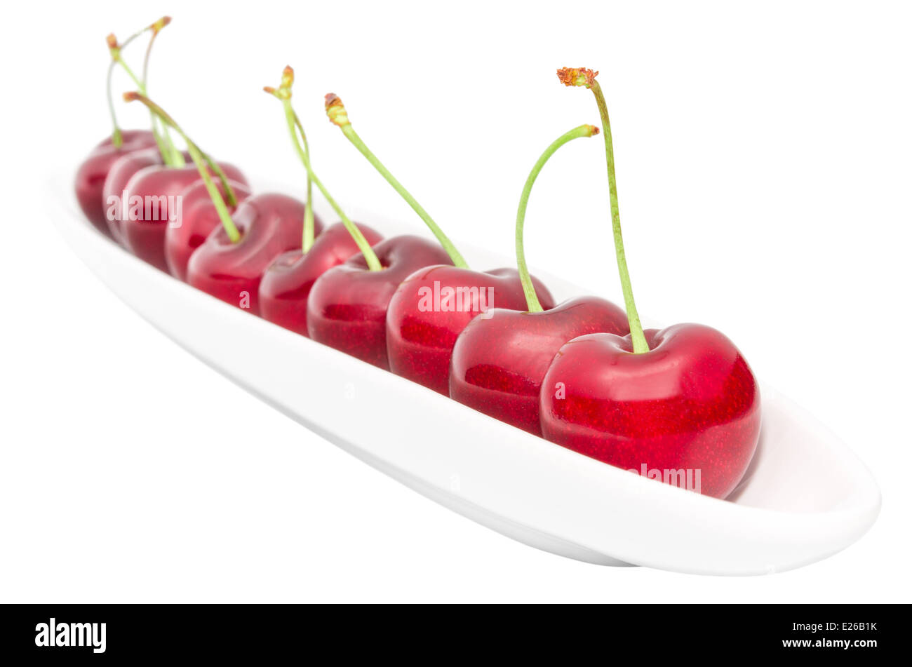 Stuzzicanti ripe cherry berry riga lunga su piatto di oliva isolato su bianco Foto Stock