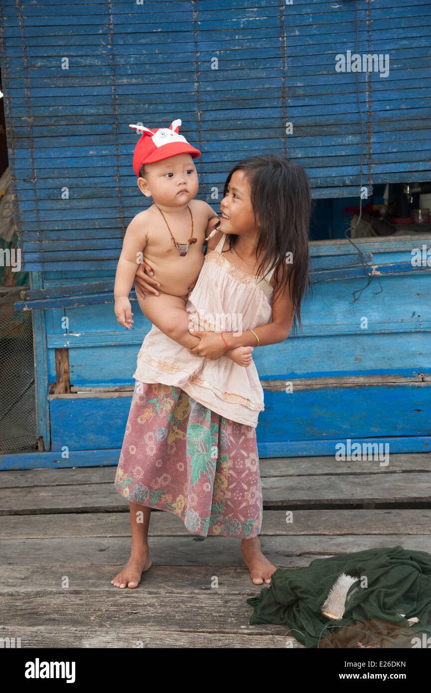 La ragazza che porta un bambino su una casa galleggiante Foto Stock