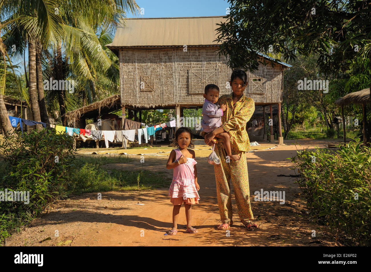 Il sambuco ragazza con suo fratello e sorella di fronte alla sua casa in legno Foto Stock