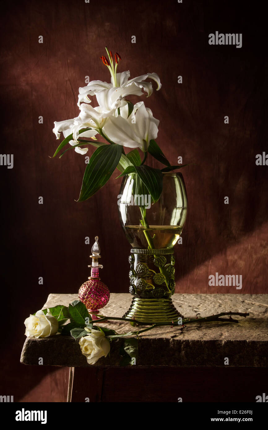 Natura morta con fiori e bottiglia di profumo Foto Stock