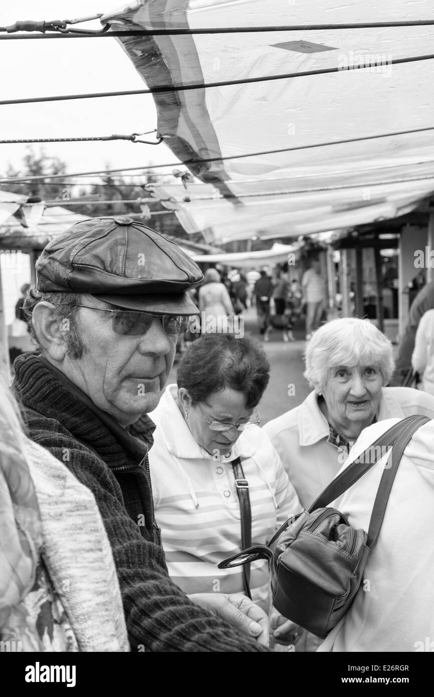 Commerciante di mercato con gli anziani clienti di sesso femminile al mercato all'aperto, Prestatyn, il Galles del Nord Regno Unito, immagine in bianco e nero. Foto Stock