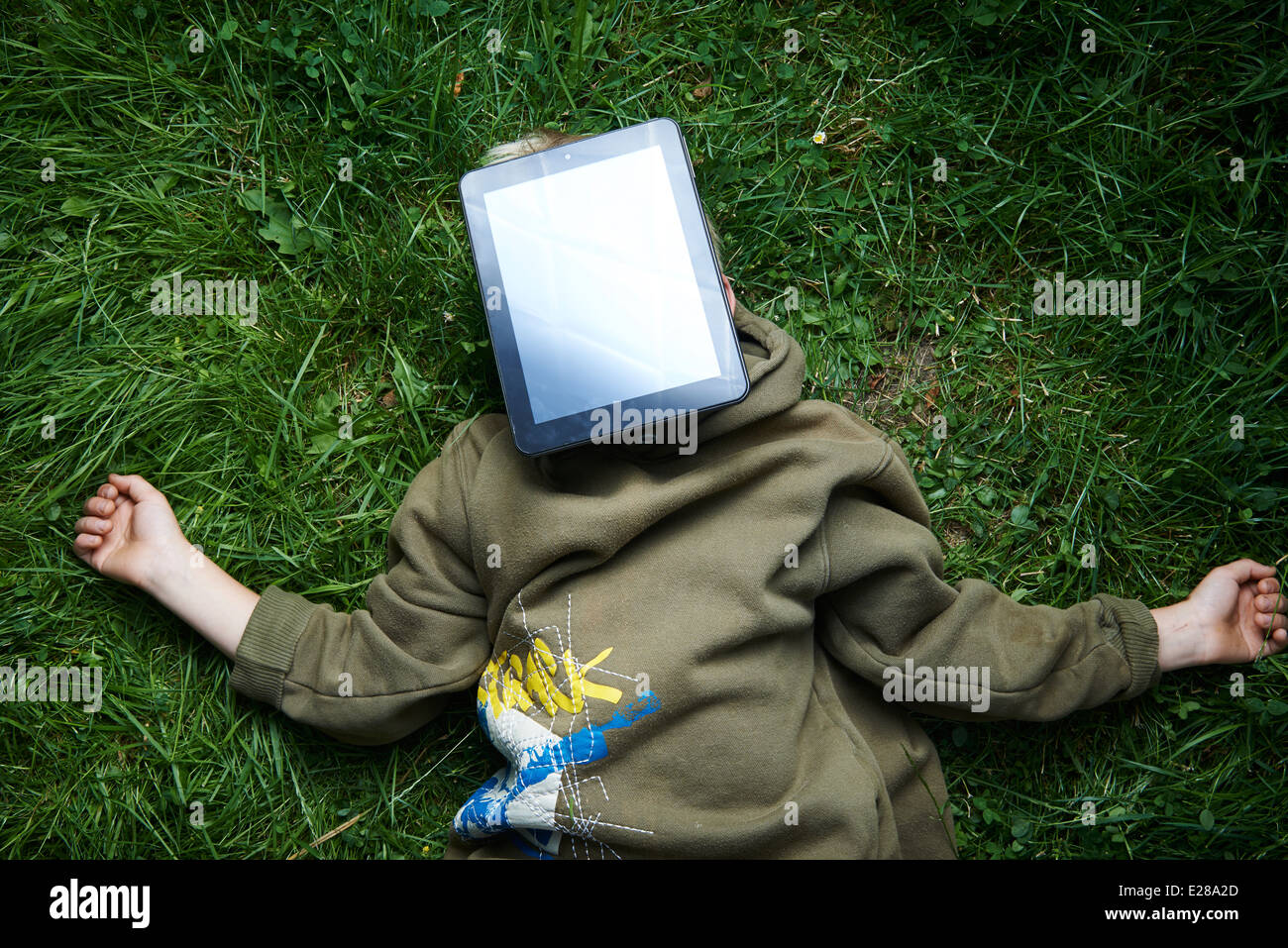 Bambino biondo giovane ragazzo giocando con una tavoletta digitale computer pc all'aperto nel parco Foto Stock