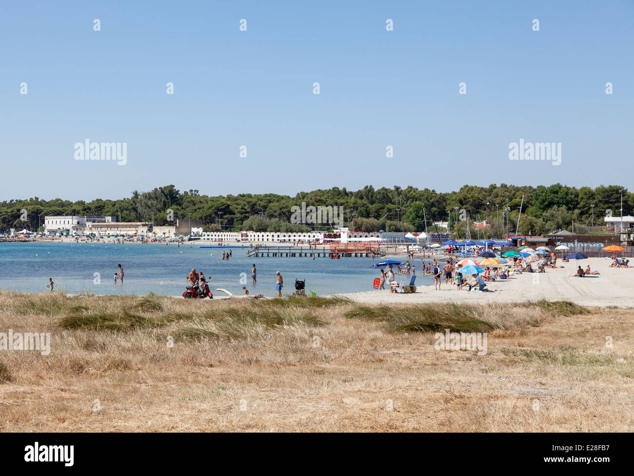 I turisti su una spiaggia di sabbia con cielo blu in una giornata di sole a San Cataldo, Puglia, Salento Italia meridionale Foto Stock