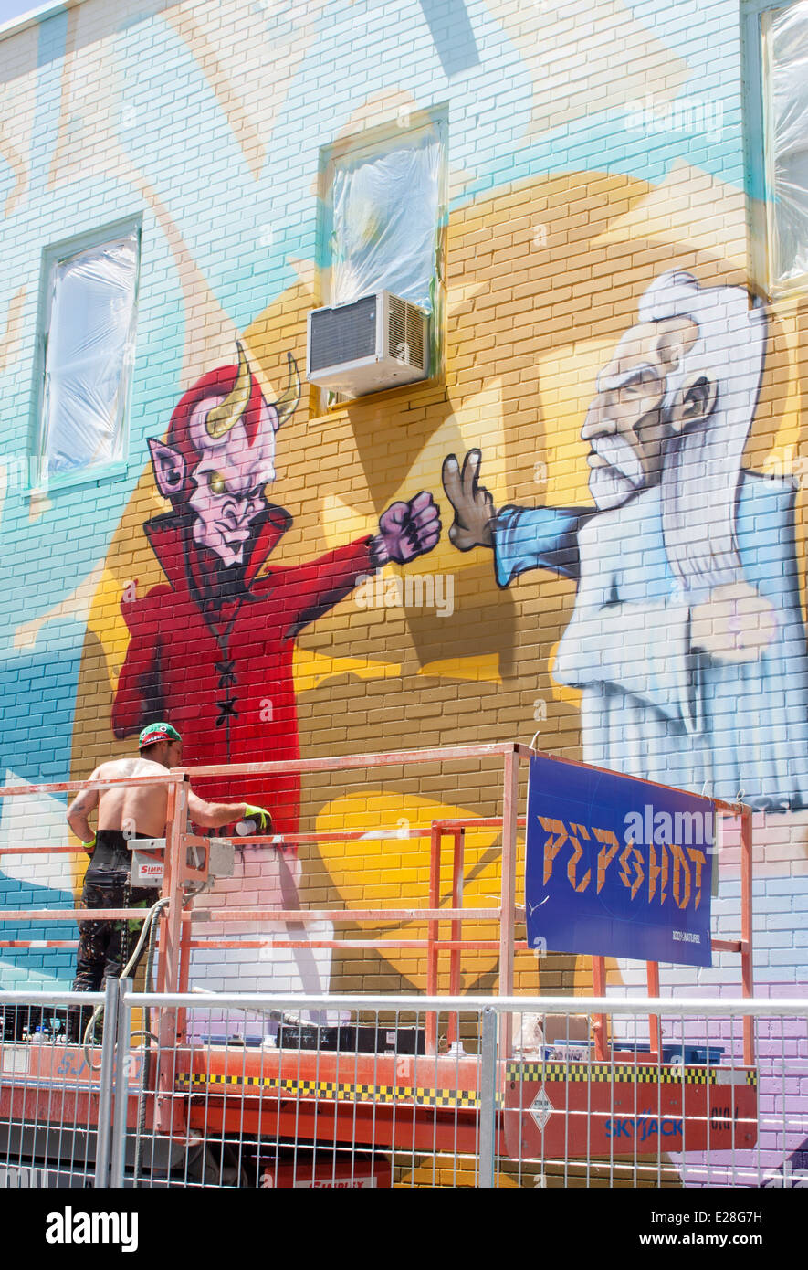 Un artista di graffiti di vernici a spruzzo una parete sul Plateau Mont-Royal durante il murale di Montreal Festival Foto Stock