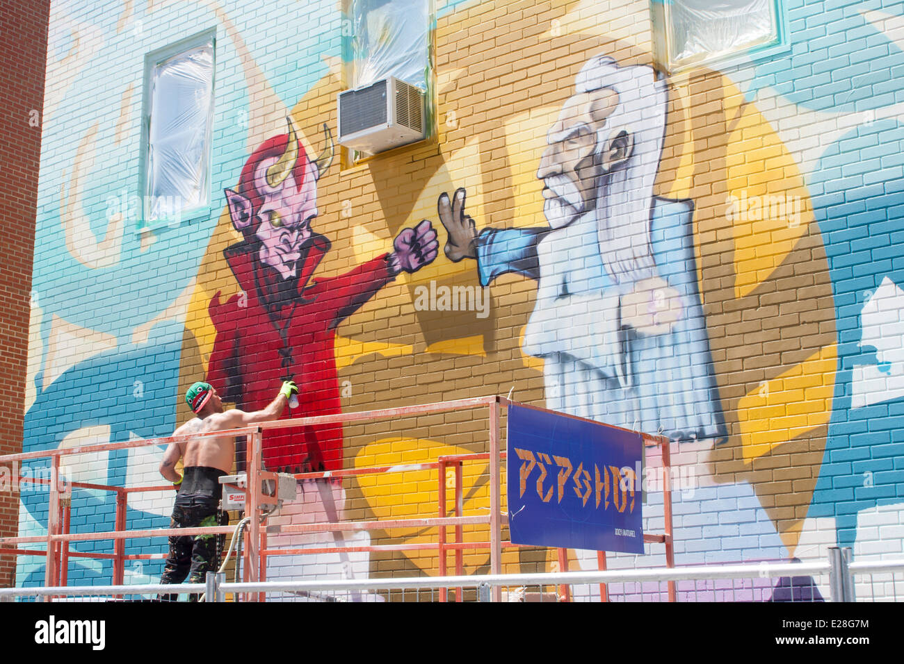 Un artista di graffiti di vernici a spruzzo una parete sul Plateau Mont-Royal durante il murale di Montreal Festival Foto Stock