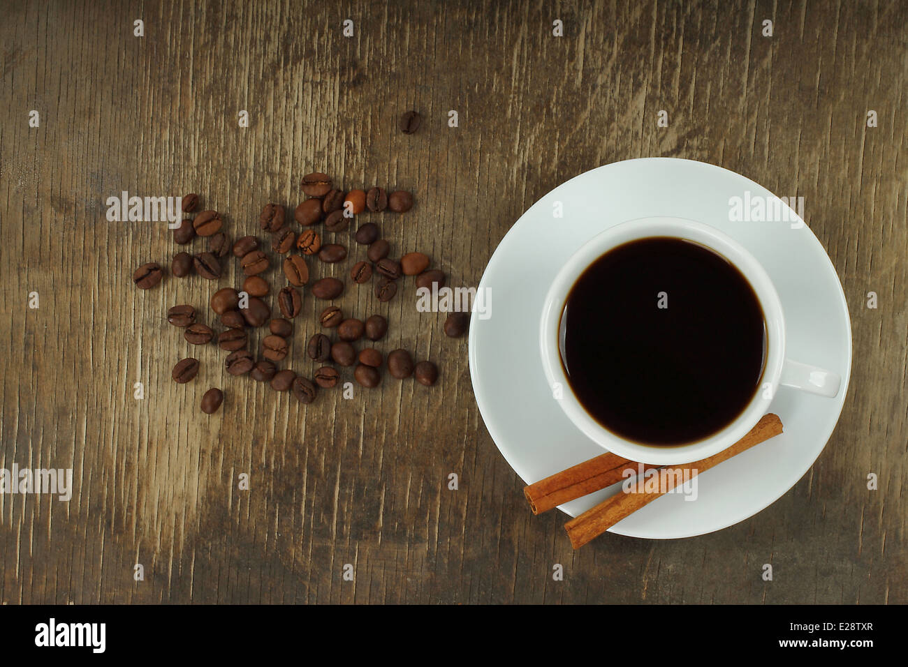 Tazza di caffè con fagioli e bastoncini di cannella su un vecchio Sfondo legno close-up Foto Stock