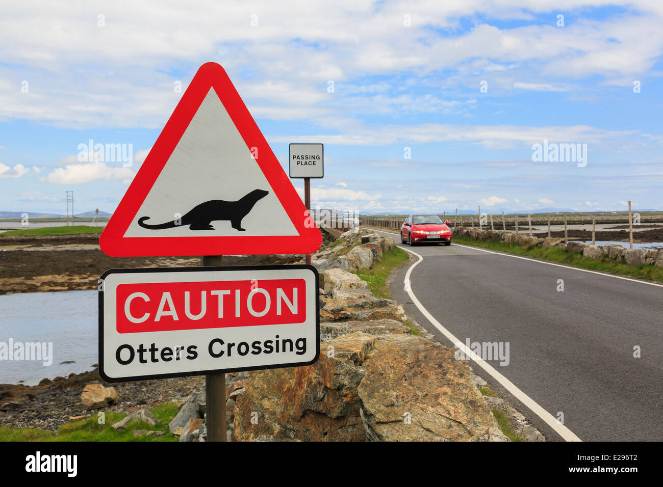 Attenzione lontre attraversando un triangolo rosso cartello stradale da causeway da Benbecula di North Uist Ebridi Esterne Western Isles della Scozia UK Gran Bretagna Foto Stock