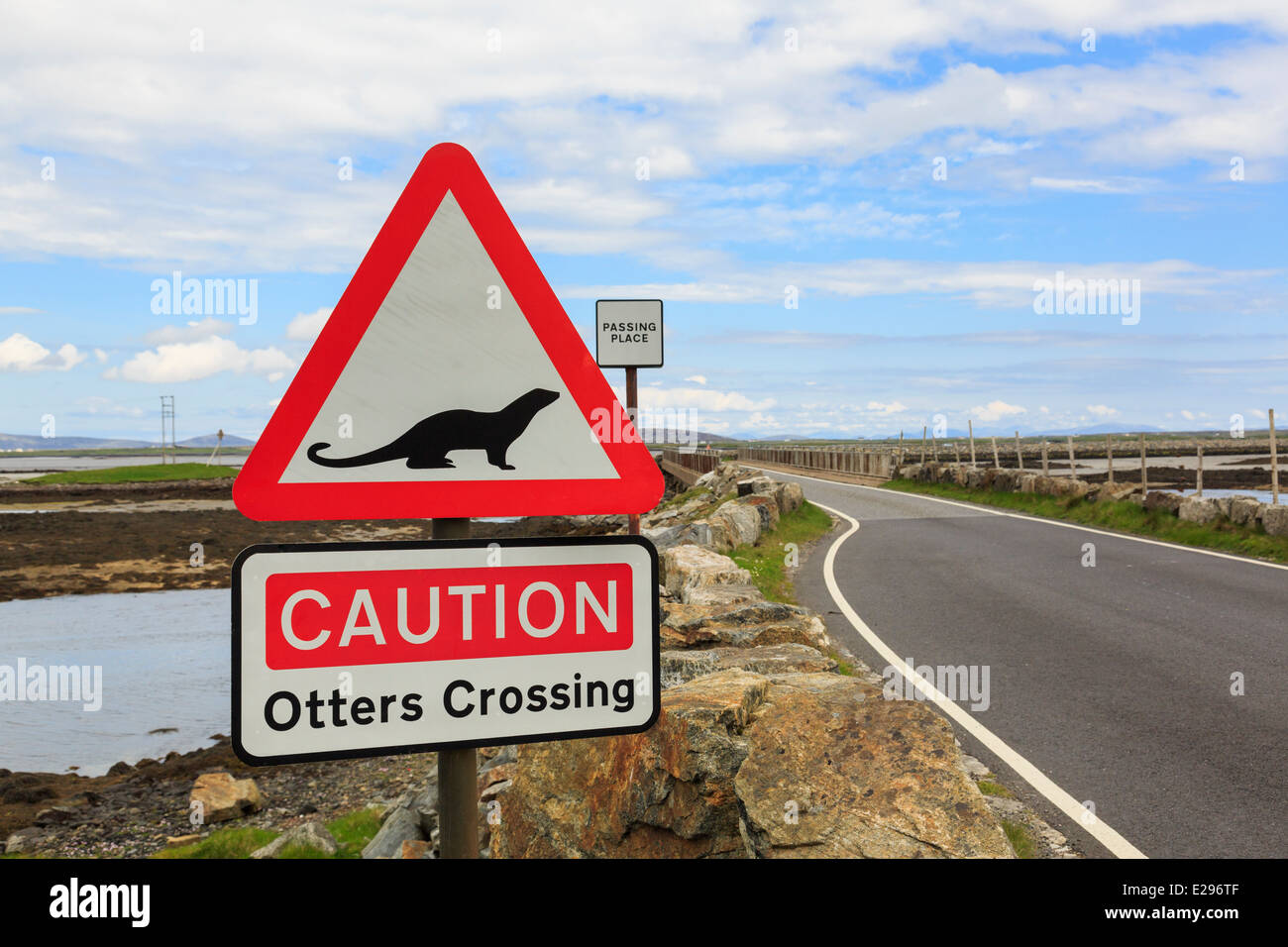 Attenzione lontre attraversando un triangolo rosso cartello stradale da causeway da Benbecula di North Uist Ebridi Esterne Western Isles della Scozia UK Foto Stock