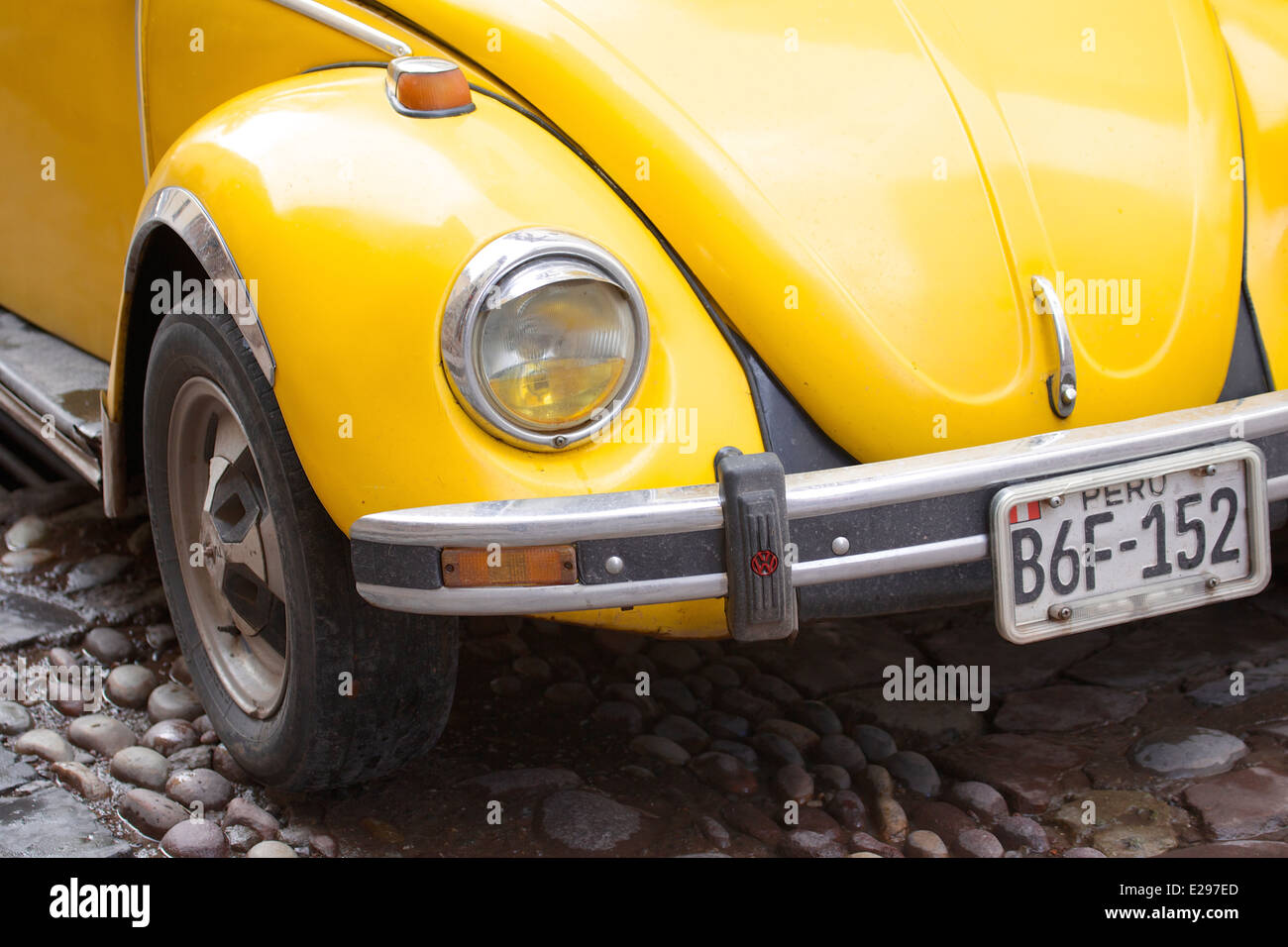 Una bella scena di strada con un giallo VW bug in Cusco, Perù, antica sede dell'Impero Inca alta delle Ande. Foto Stock