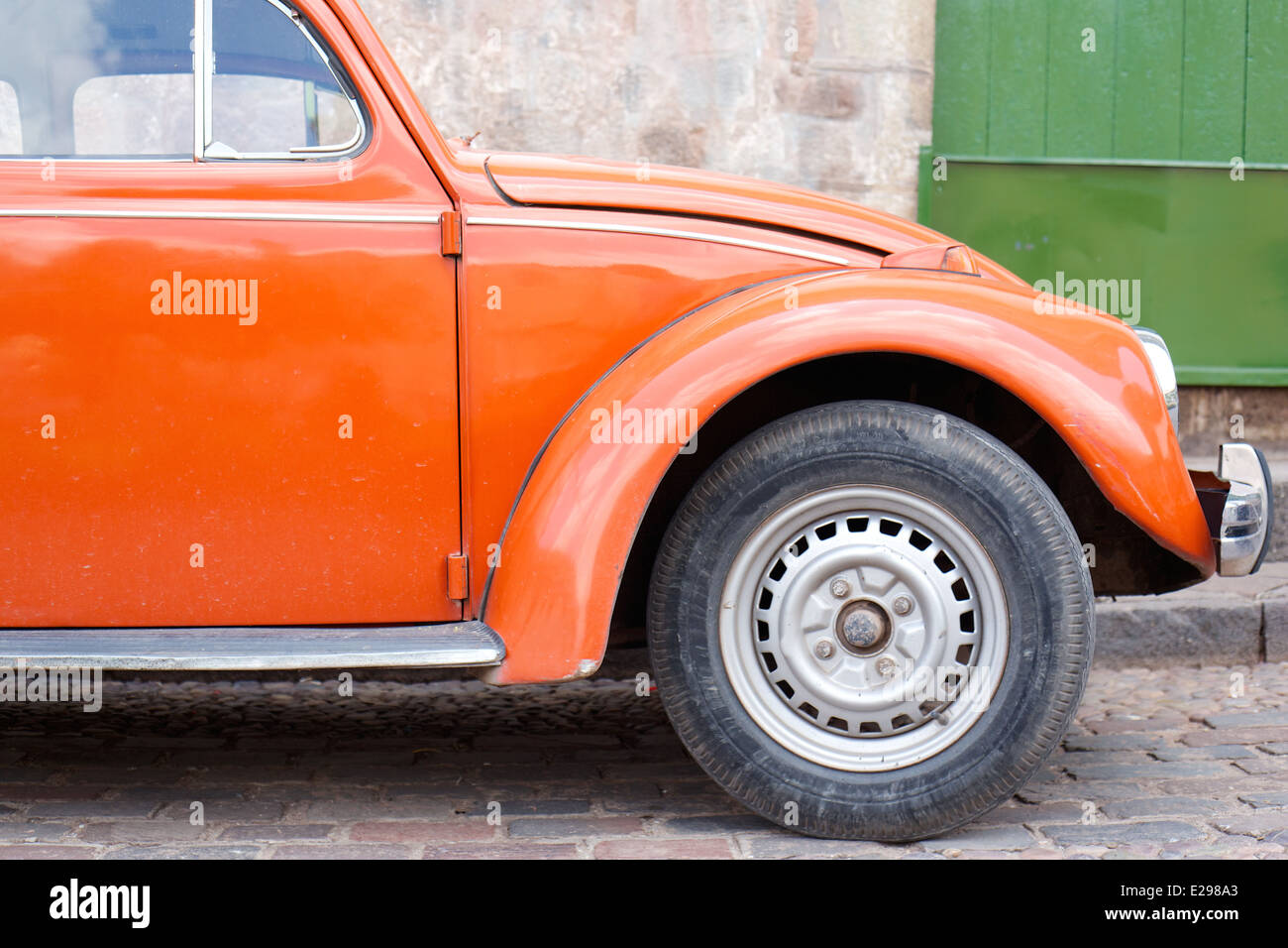 Una bella scena di strada con orange VW bug Cusco, Perù, antica sede dell'Impero Inca alta delle Ande. Foto Stock