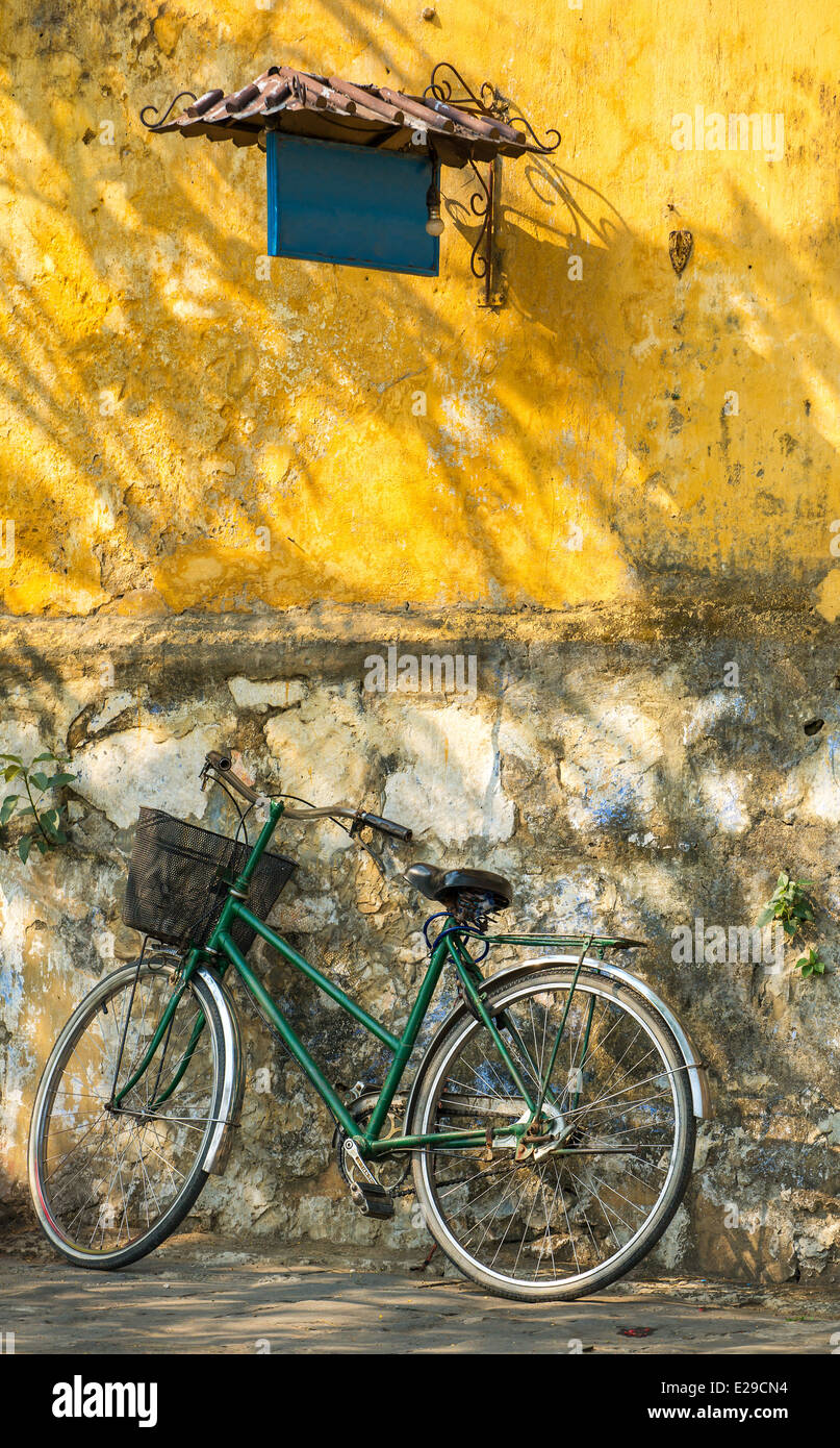 Vecchia bicicletta contro grungy sfondo a parete Foto Stock