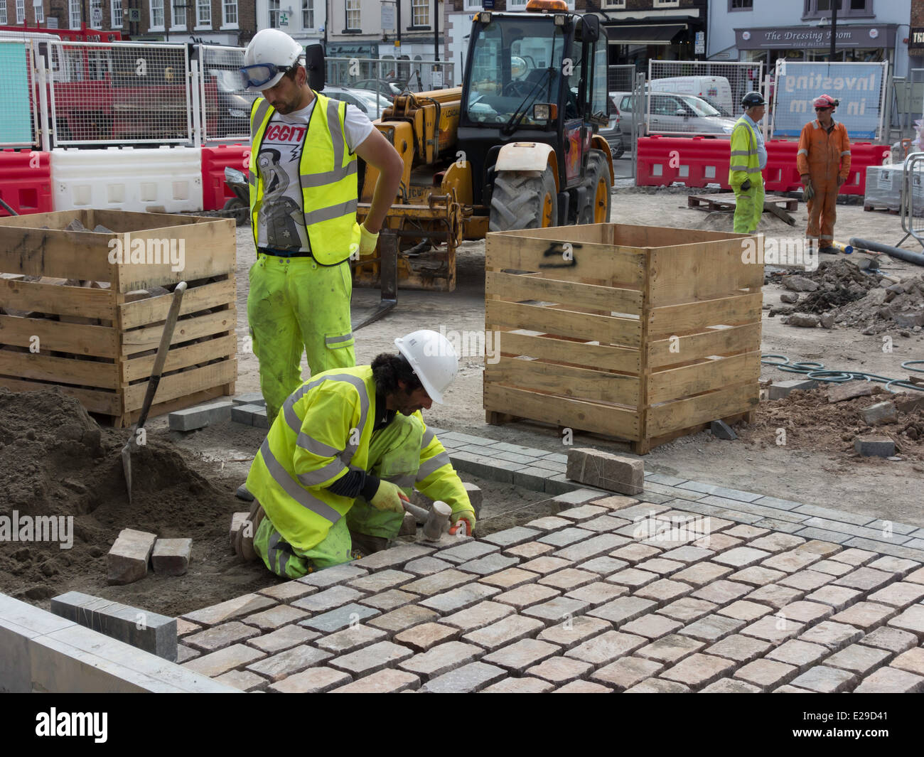 Operai che stabilisce un nuovo blocco di granito la superficie stradale da Yarm Municipio controversi come esso ha sostituito antichi ciottoli 2014 Foto Stock