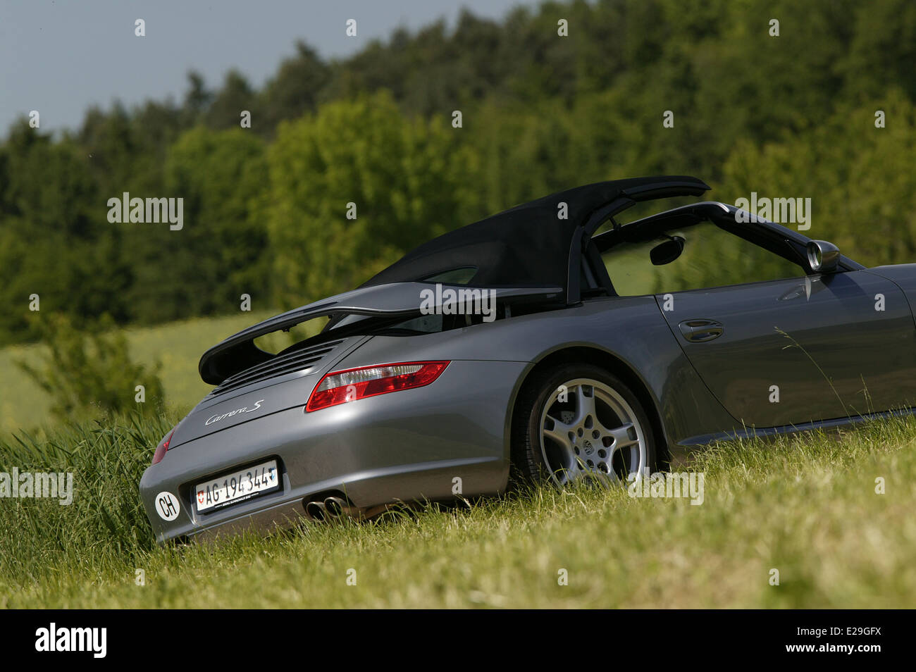 Porsche 997 Carrera S cabriolet in argento - guida con tetto essendo retratto Foto Stock