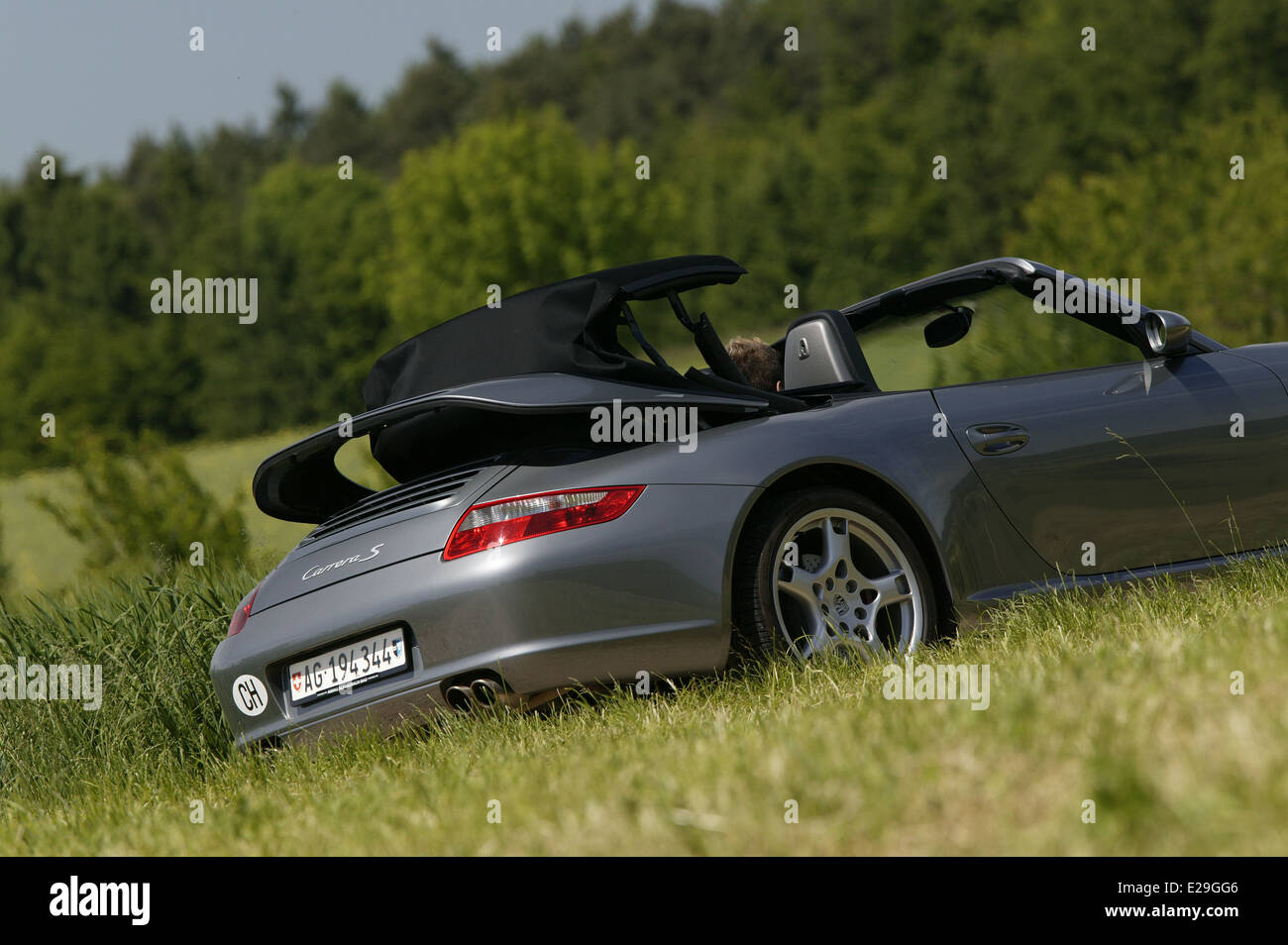 Porsche 997 Carrera S cabriolet in argento - guida con tetto essendo retratto Foto Stock