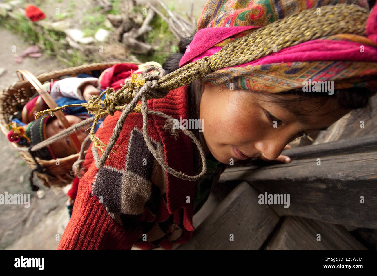 Il Nepal, zona di Bagmati, Distretto Rasuwa, Trisuli Valley, Gatlang, Tamang Heritage Trail, donna che indossa il suo bambino sulla fronte Foto Stock