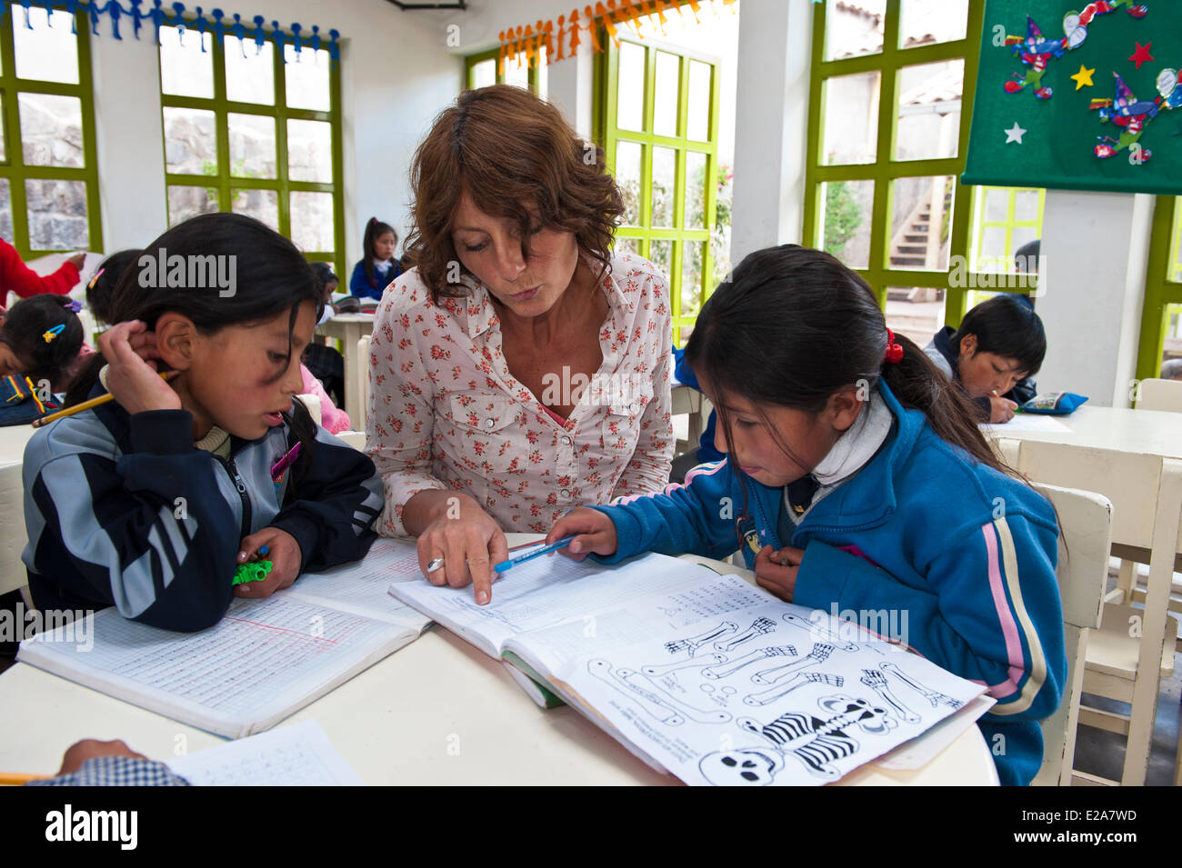 Il Perù, Provincia di Cuzco, Cuzco, ragazze facendo loro homeworks con l aiuto di Jolanda Van den Berg in uno dei 5 centri educativi Foto Stock