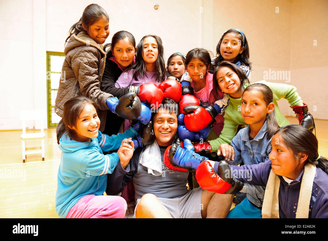 Il Perù, Provincia di Cuzco, Cuzco, ragazze che circonda il loro insegnante di boxe durante un auto-difesa sessione nella palestra di uno dei Foto Stock