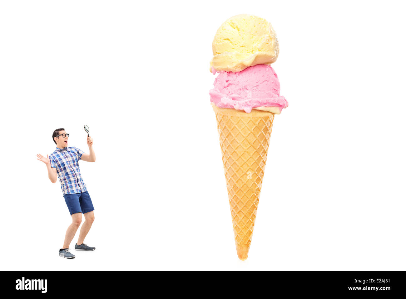 Uomo eccitato guardando un gelato attraverso una lente di ingrandimento Foto Stock