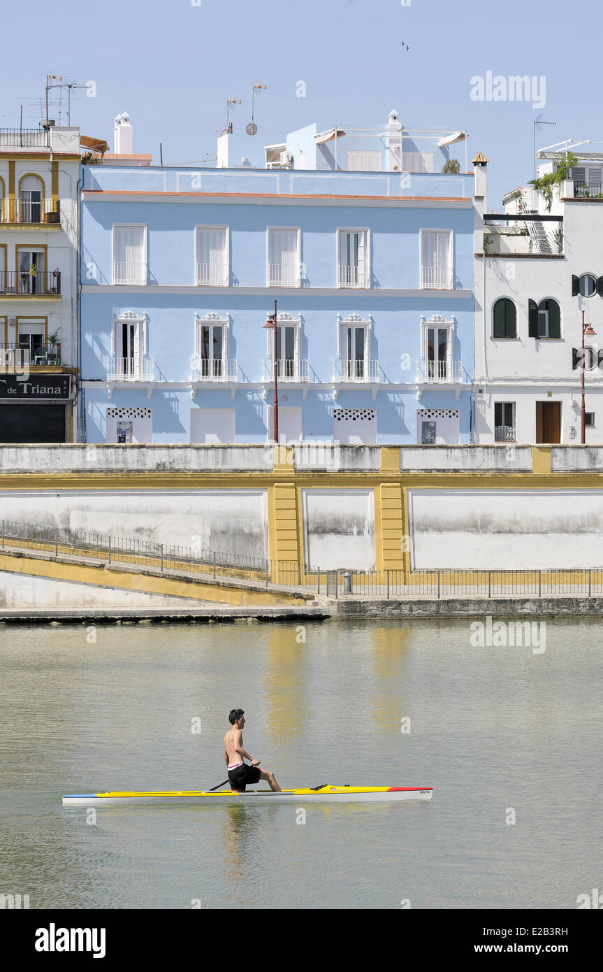 Spagna, Andalusia Siviglia, Triana, l uomo nel suo skiff sul fiume Guadalquivir, blu facciata su Calle Betis Foto Stock