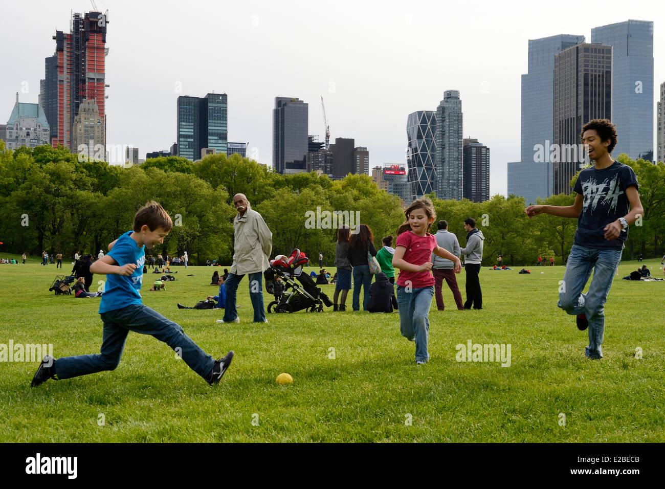 Stati Uniti, New York City, Manhattan, Central Park, bambini che giocano a  calcio sul prato di pecora, Central Park South edifici in background Foto  stock - Alamy