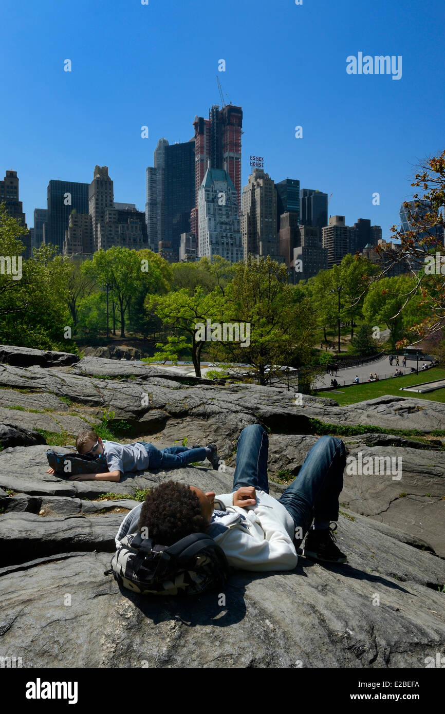Stati Uniti, New York City, Manhattan, Central Park, le rocce vicino al laghetto e gli edifici di Midtown in background Foto Stock