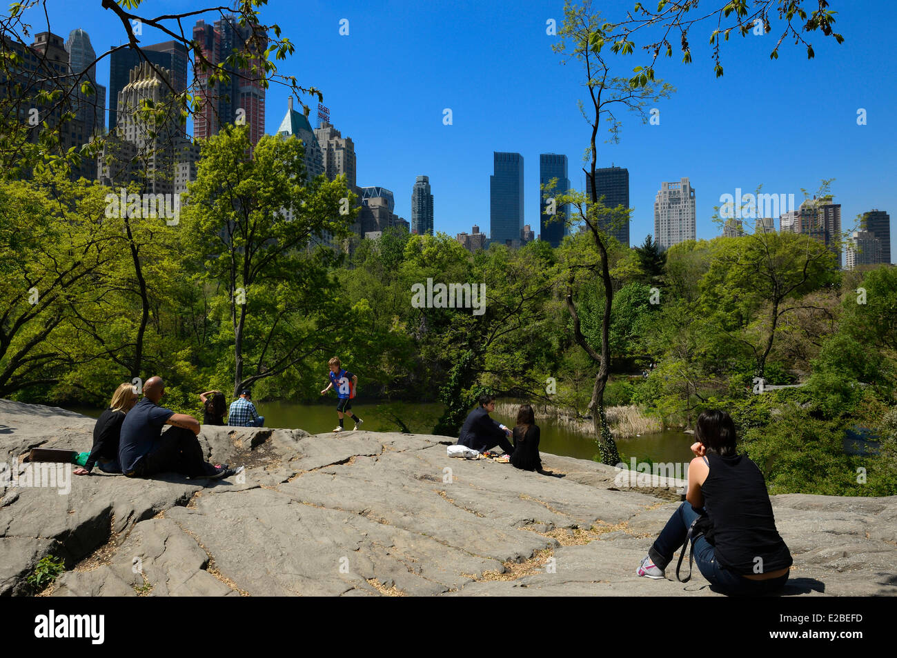 Stati Uniti, New York City, Manhattan, Central Park, le rocce vicino al laghetto, edifici di Midtown e il Time Warner Center Foto Stock