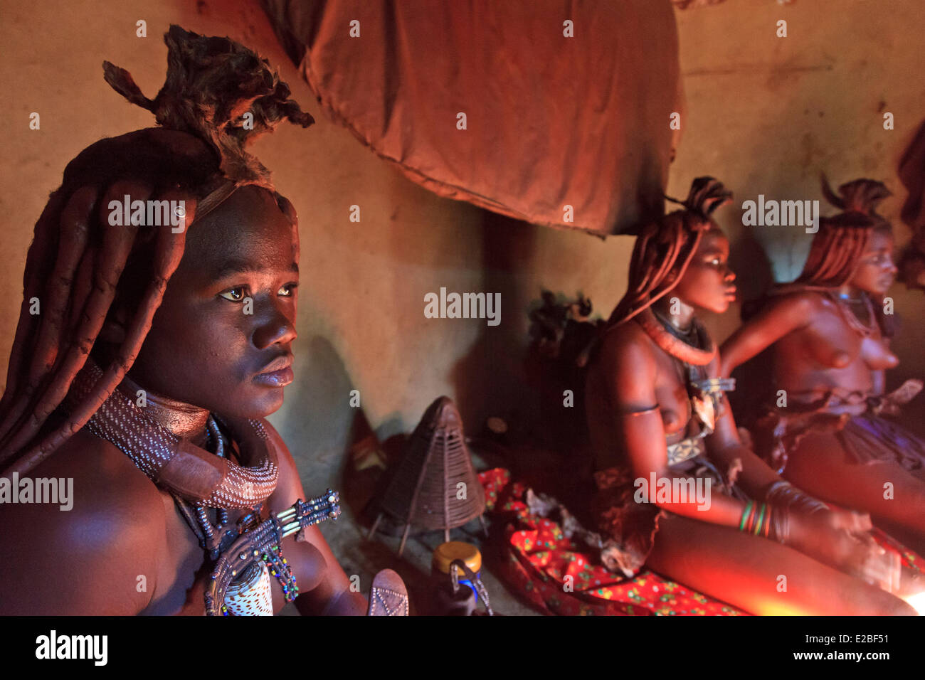 La Namibia, Regione di Kunene, Kaokoland o Kaokoveld, le donne himba in un villaggio, Bantu gruppo etnico, corpo coperto con ematite ocra Foto Stock
