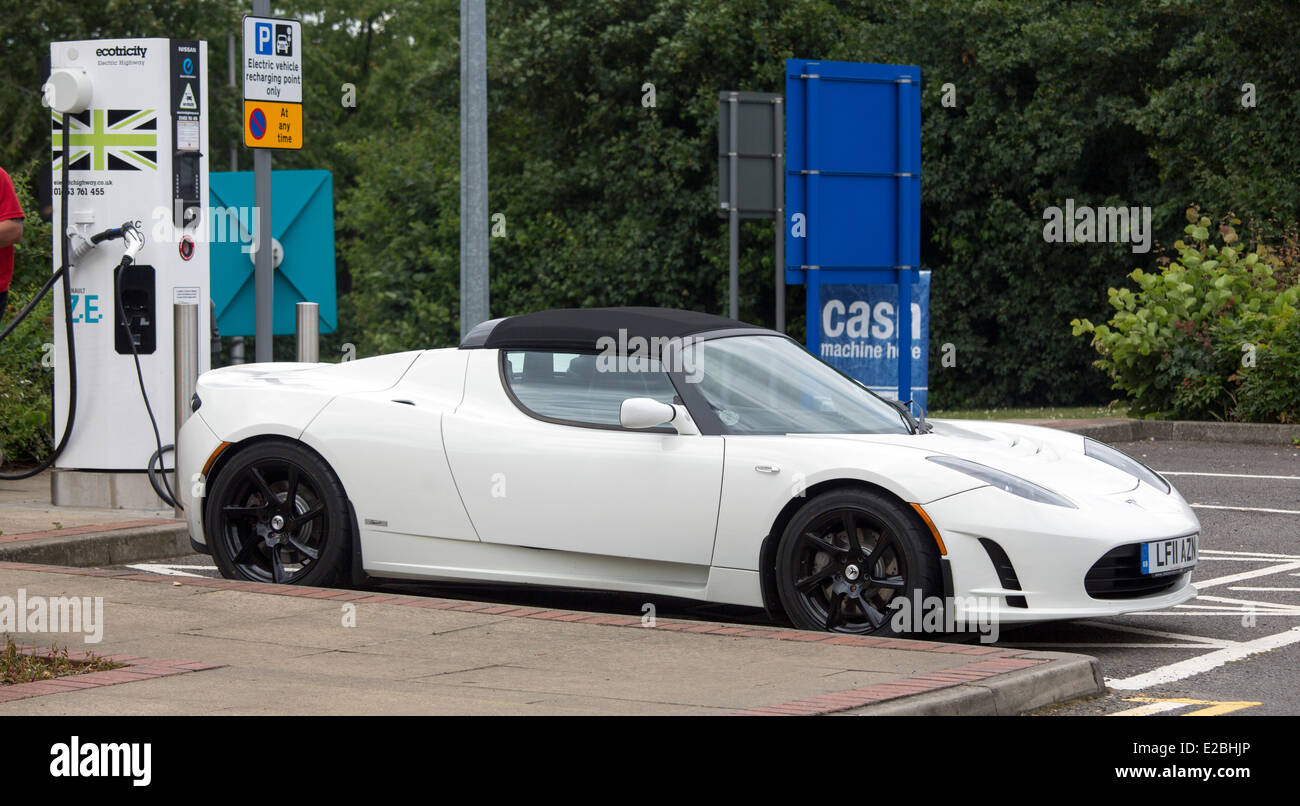 La Tesla Roadster elettrica auto supercar sulla carica a Heston Servizi. batteria veicolo elettrico (BEV) auto sportiva può fare 0-60 mi Foto Stock