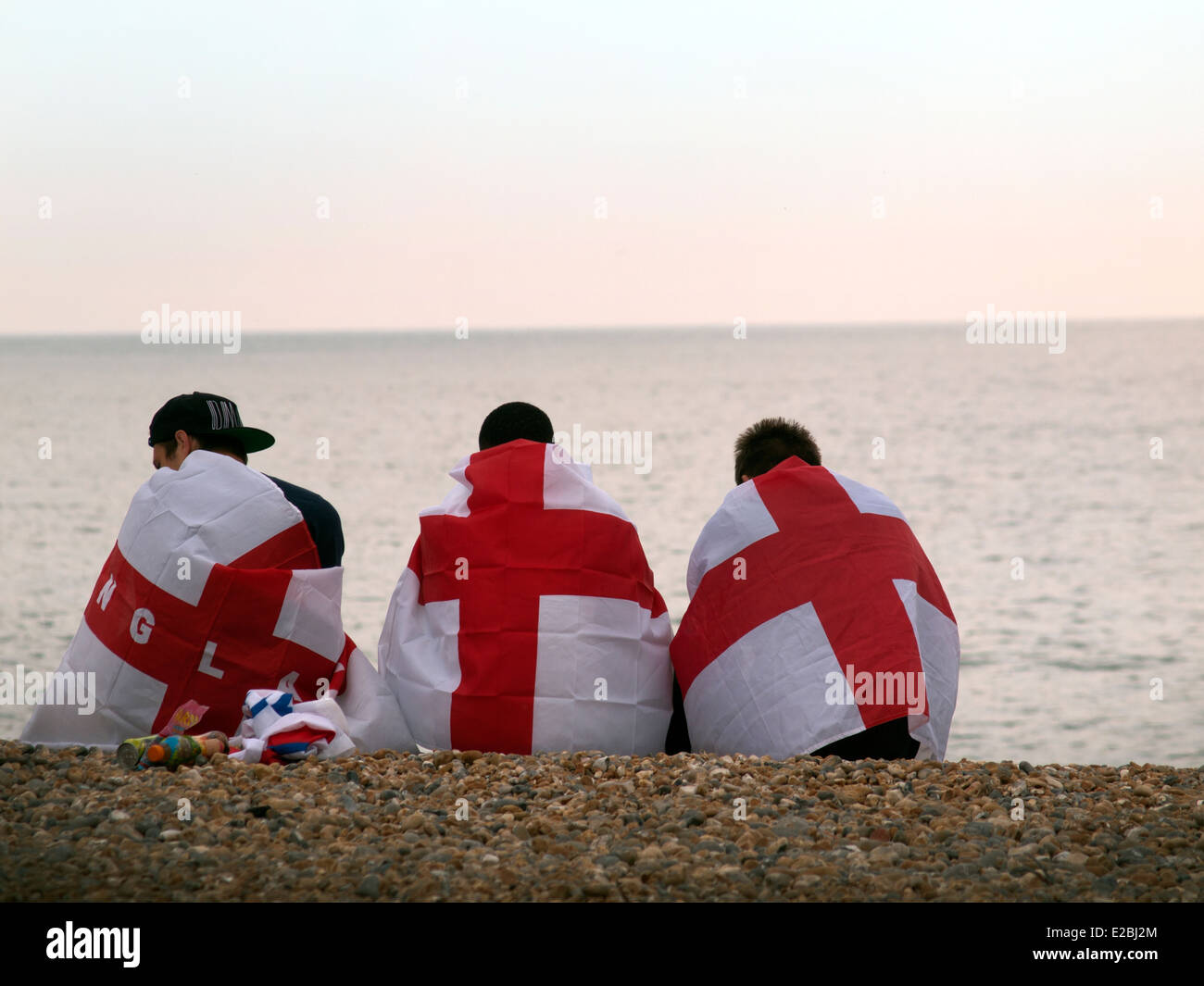 Sconsolato England Football Fans sedersi sulla spiaggia di Brighton l'ultimo giorno del loro team è povero mostrano nella Coppa del Mondo 2014 Foto Stock