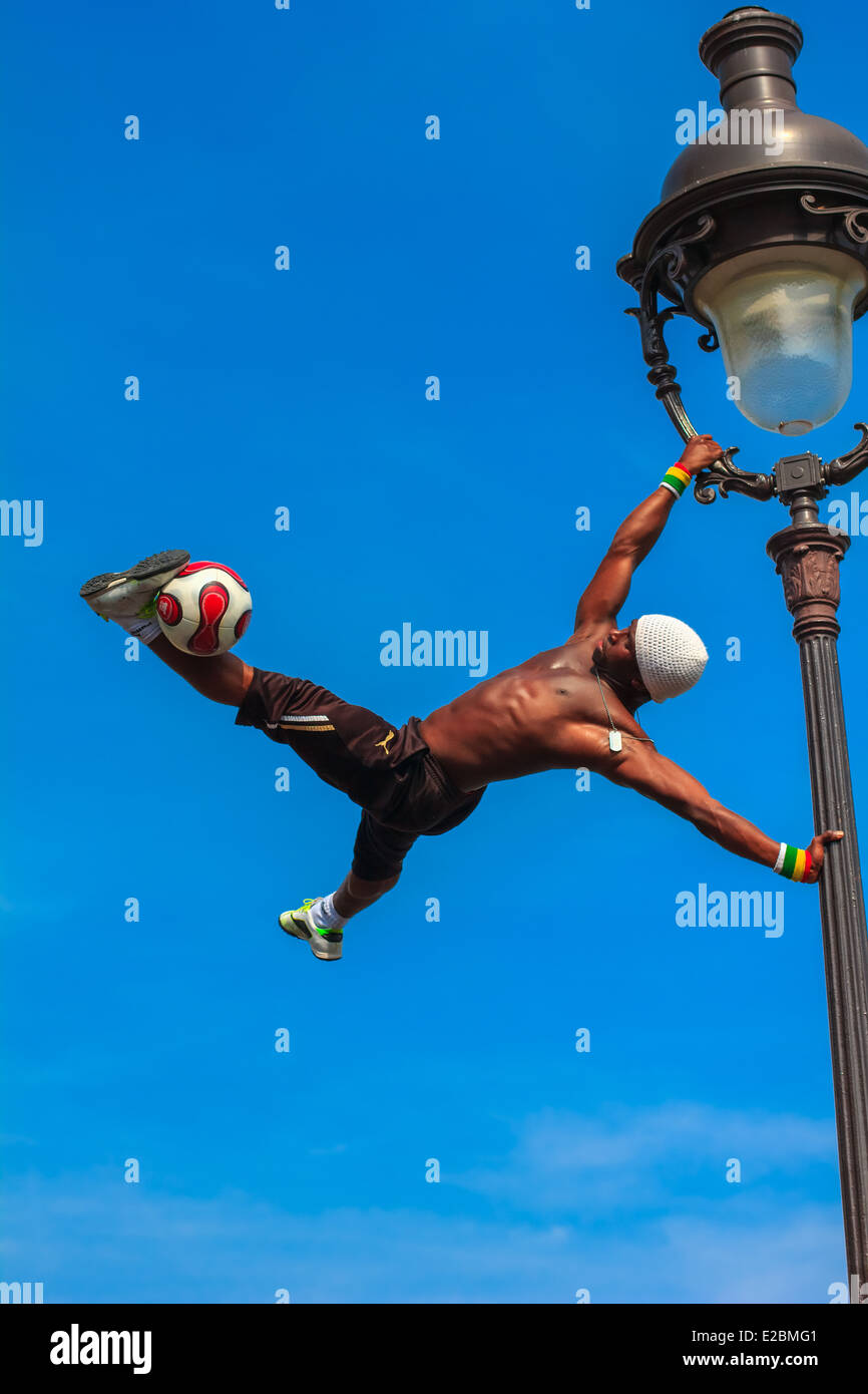 Incredibile il calcio freestyle Íýá Traore appeso sul lampione e giochi di prestigio di un pallone da calcio di fronte della chiesa del Sacro Cuore Foto Stock