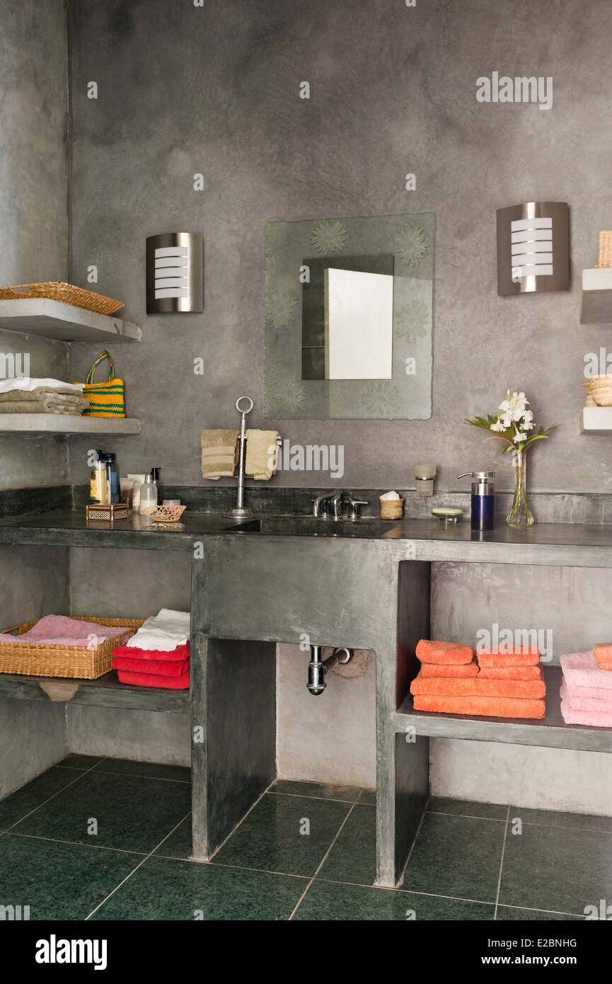 Bagno di colore grigio con cemento lucidato superfici in Baja home inglese di interior designer Jenny Armit Foto Stock