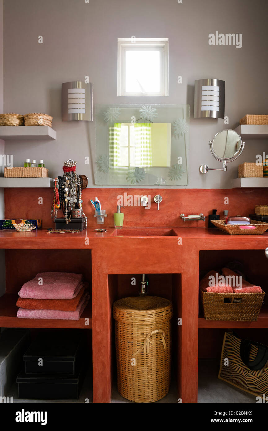 Bagno di colore arancione con cemento lucidato unità in Baja home inglese di interior designer Jenny Armit Foto Stock