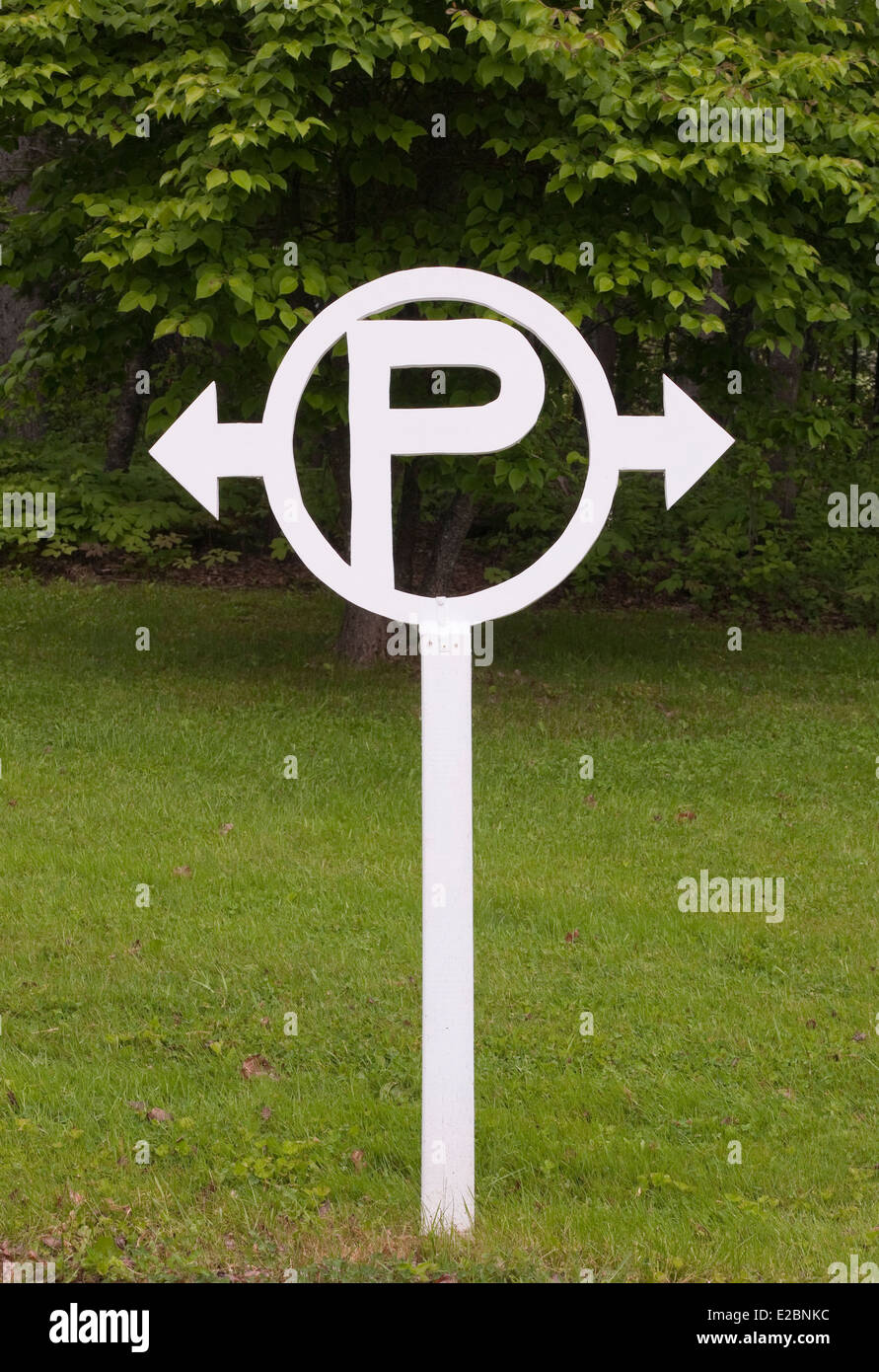 Area di parcheggio segno sull'erba con foglie di albero in backgrond. Foto Stock