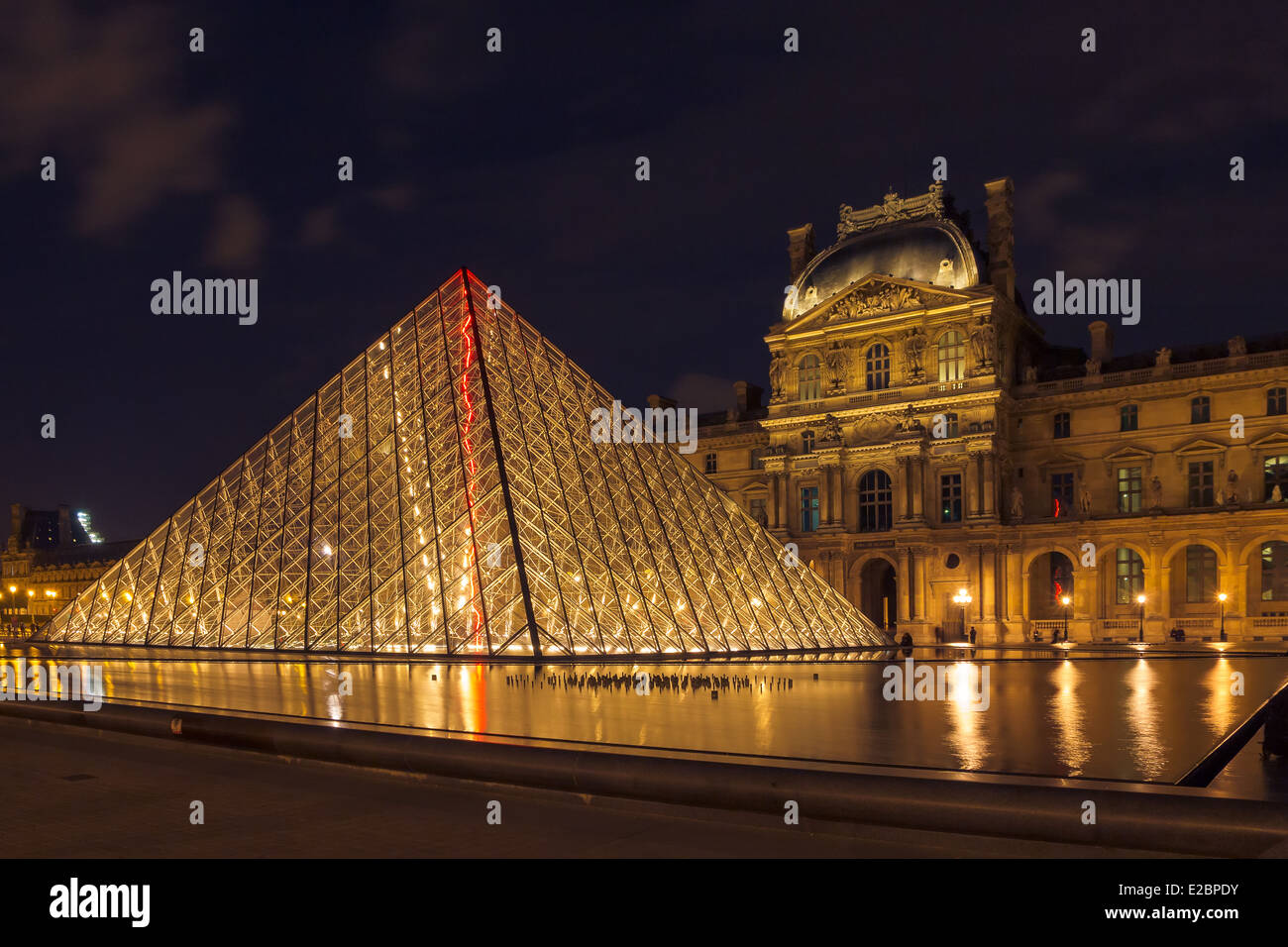 Il museo del Louvre e la Piramide a Parigi presso l'illuminazione notturna Foto Stock
